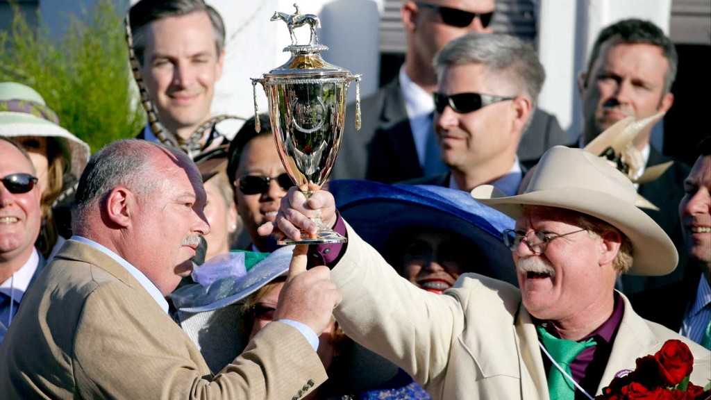 California Chrome owners Steven Coburn, right, and Perry Martin hold the trophy after Victor Espinoza rode California Chrome to victory in the 140th running of the Kentucky Derby horse race at Churchill Downs Saturday, May 3, 2014, in Louisville, Ky. (AP Photo/David Goldman)